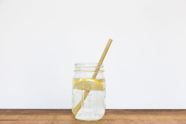 Lemon water and bamboo drinking straw.