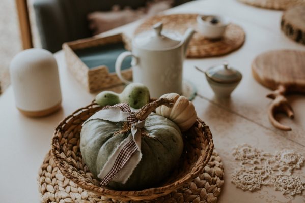 A closeup high angle shot of a rural table with a couple of small pumpkins in a straw plate