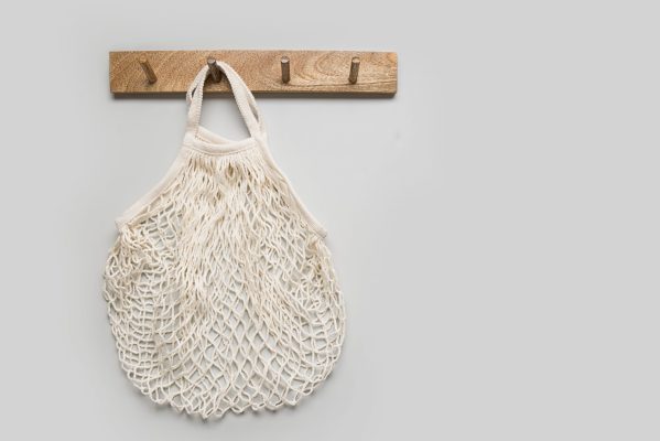 Empty cotton shopping eco bag hang on hanger on wall. Ready for shopping. Copy space. Zero waste concept.