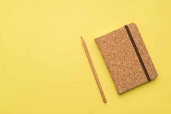 Photo overhead of wood notepad and pencil on isolated the yellow background